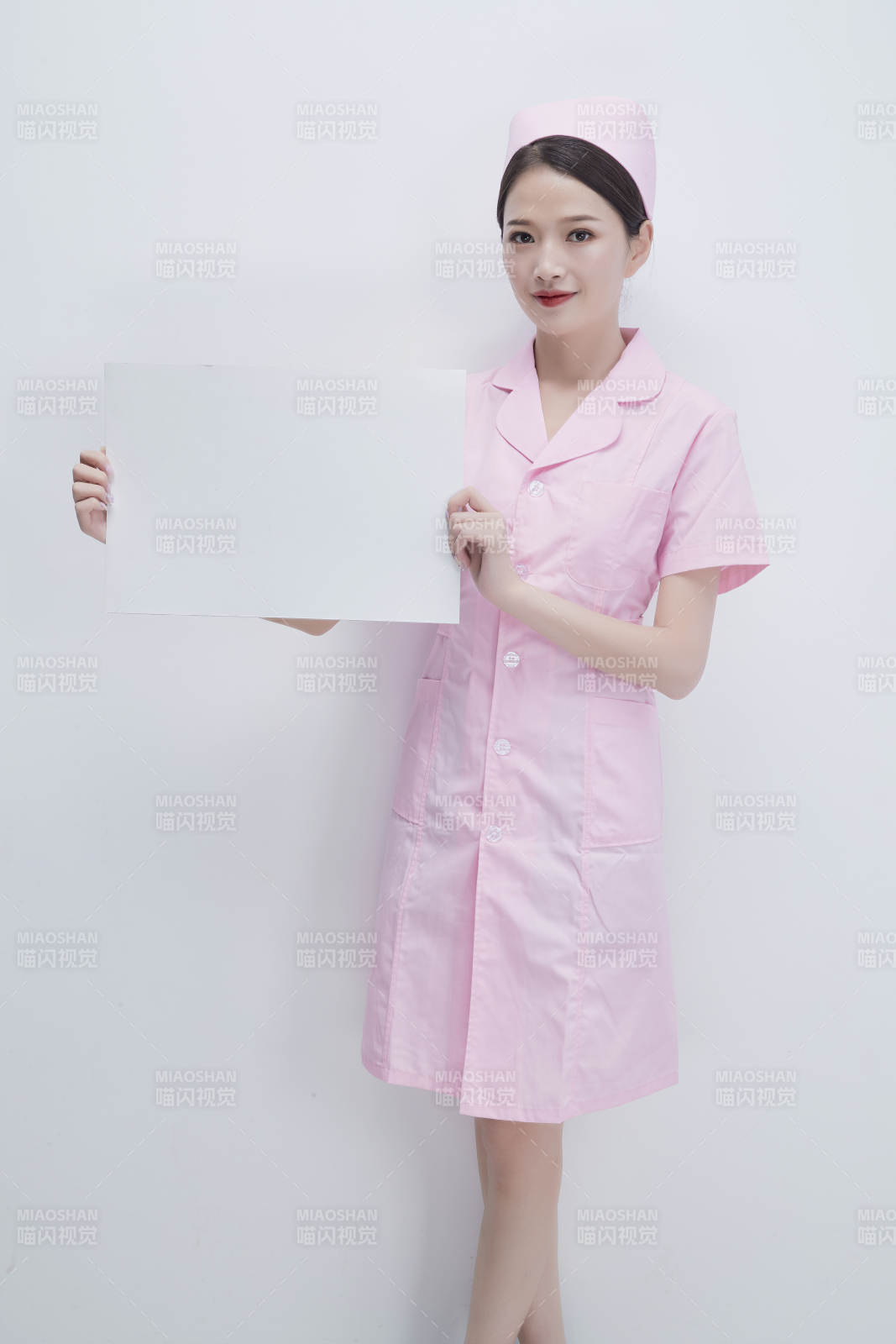 身穿粉色护士服佩戴听诊器的女性医护人员图片