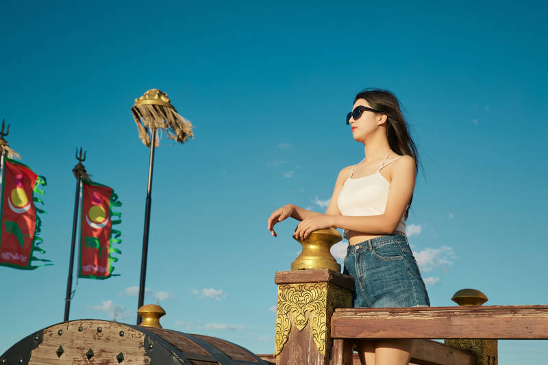 草原湿地公园游玩拍照的亚洲少女图片