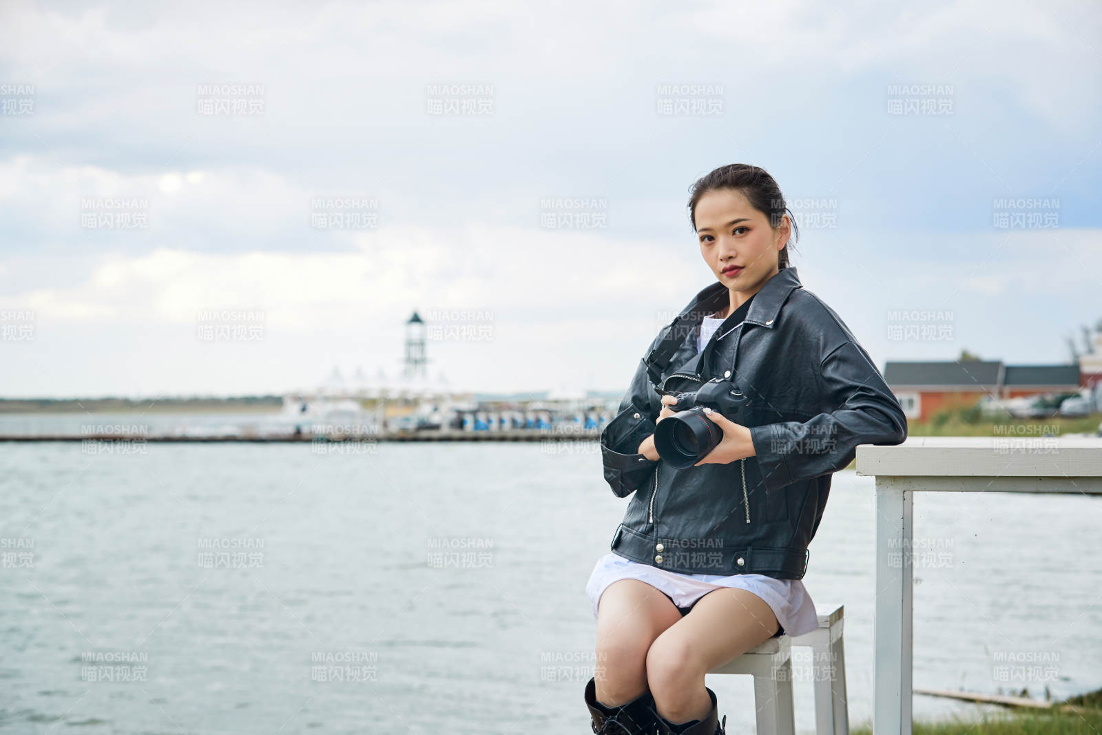 户外湖畔进行拍摄的亚洲青年女性摄影师图片