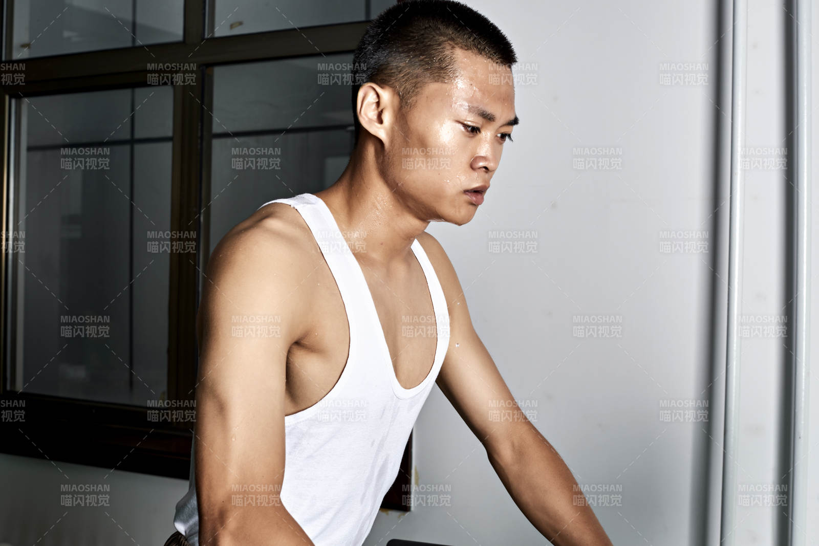 在室内用跑步机进行锻炼的亚洲健身男士形象图片