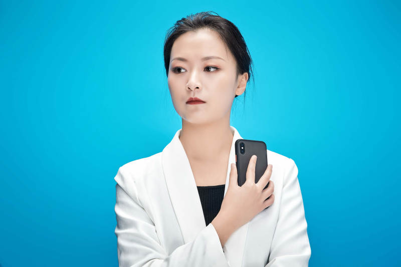 身穿西服拿着手机与文件夹的亚洲商务女士图片