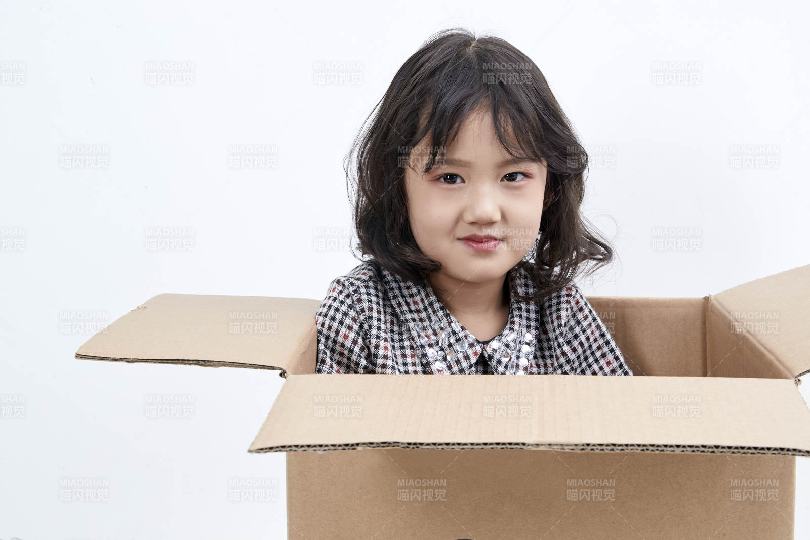 躲在纸箱中玩耍的调皮可爱亚洲小女孩儿童图片