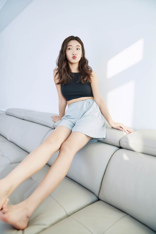 在家在沙发上享受美食的亚洲少女图片