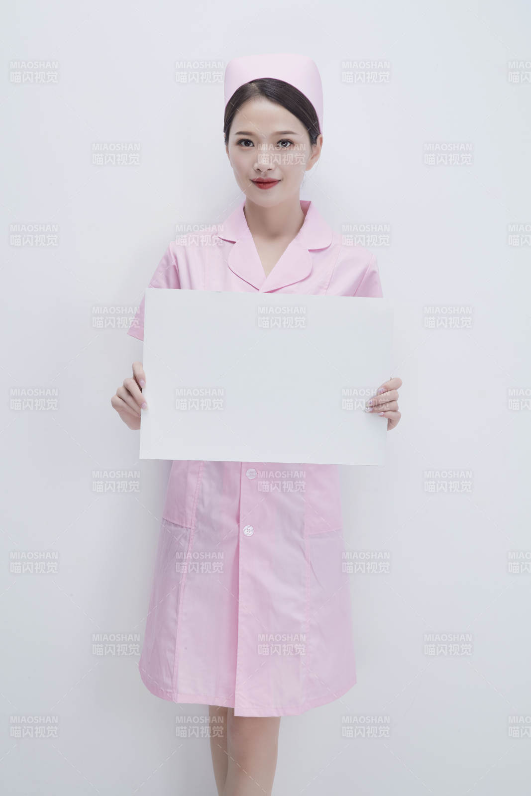 身穿粉色护士服佩戴听诊器的女性医护人员图片