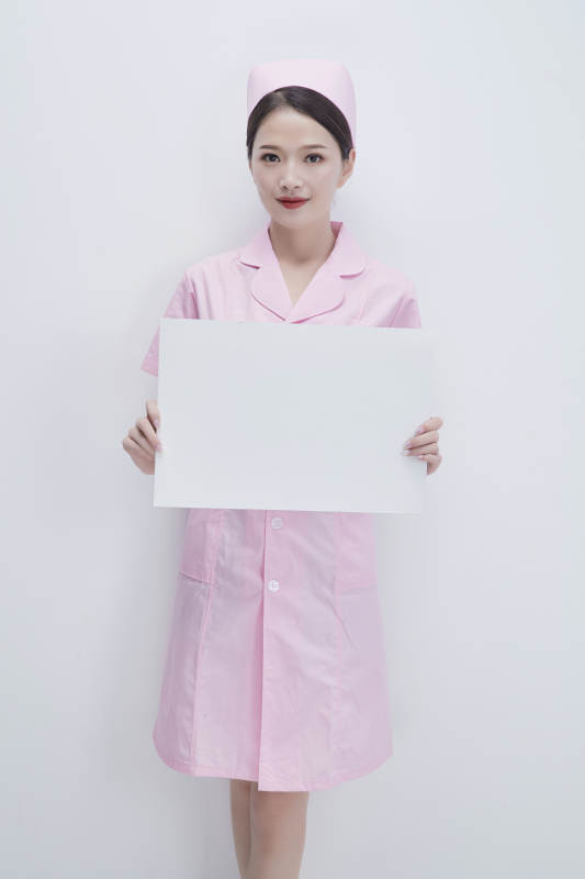 身穿粉色护士服佩戴听诊器的女性医护人员图片