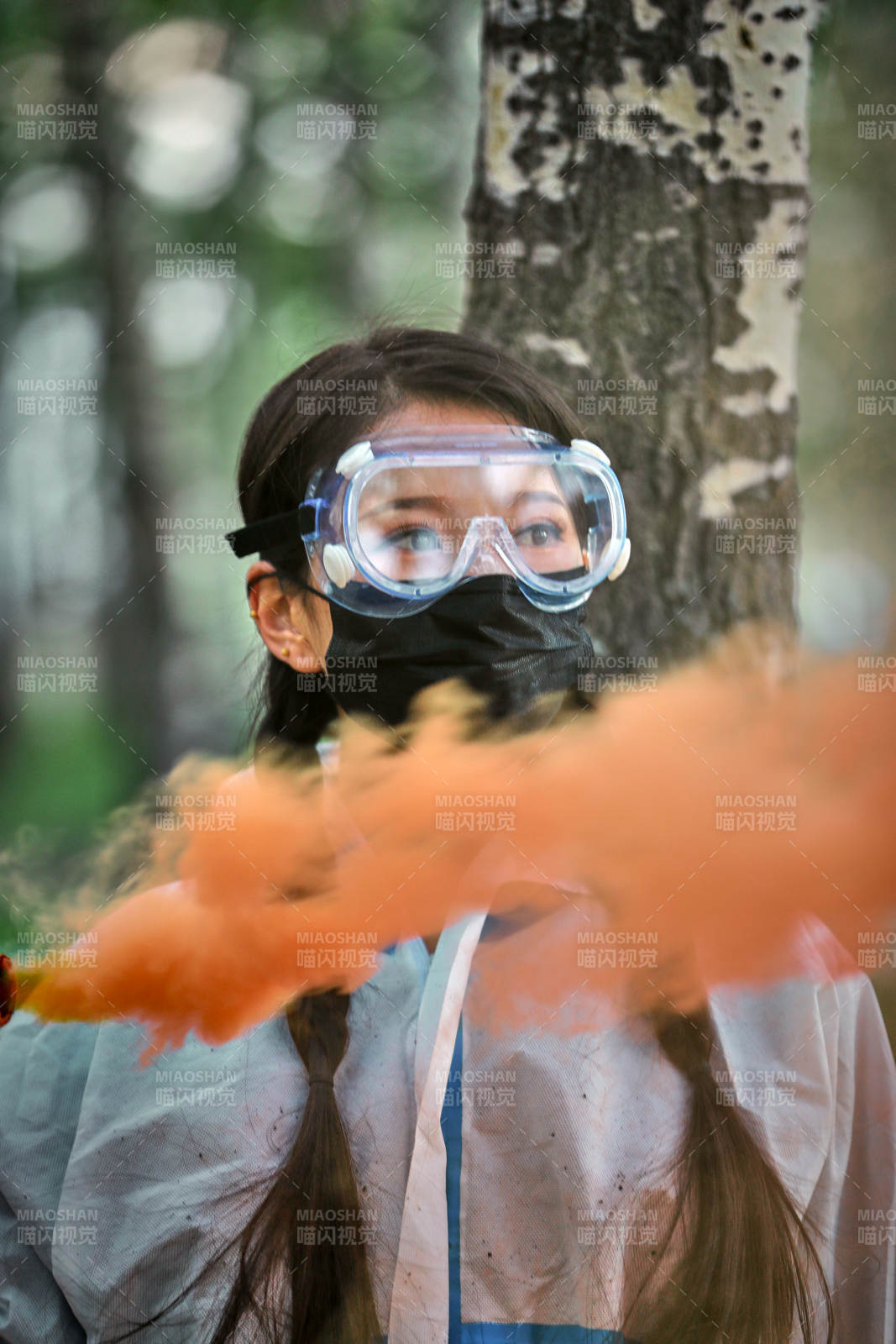 手执彩烟身穿防护服装的女性医疗人员图片