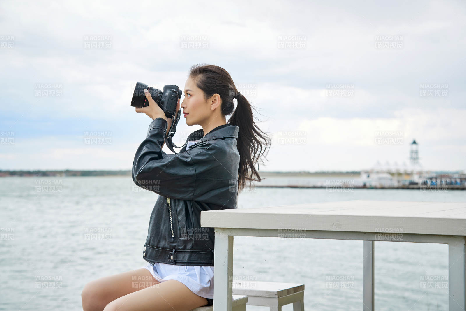户外湖畔进行拍摄的亚洲青年女性摄影师图片
