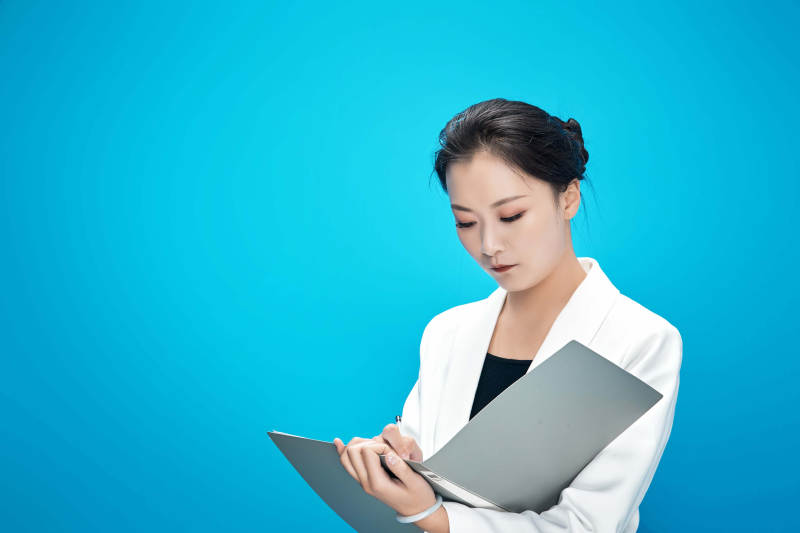 身穿西服拿着手机与文件夹的亚洲商务女士图片