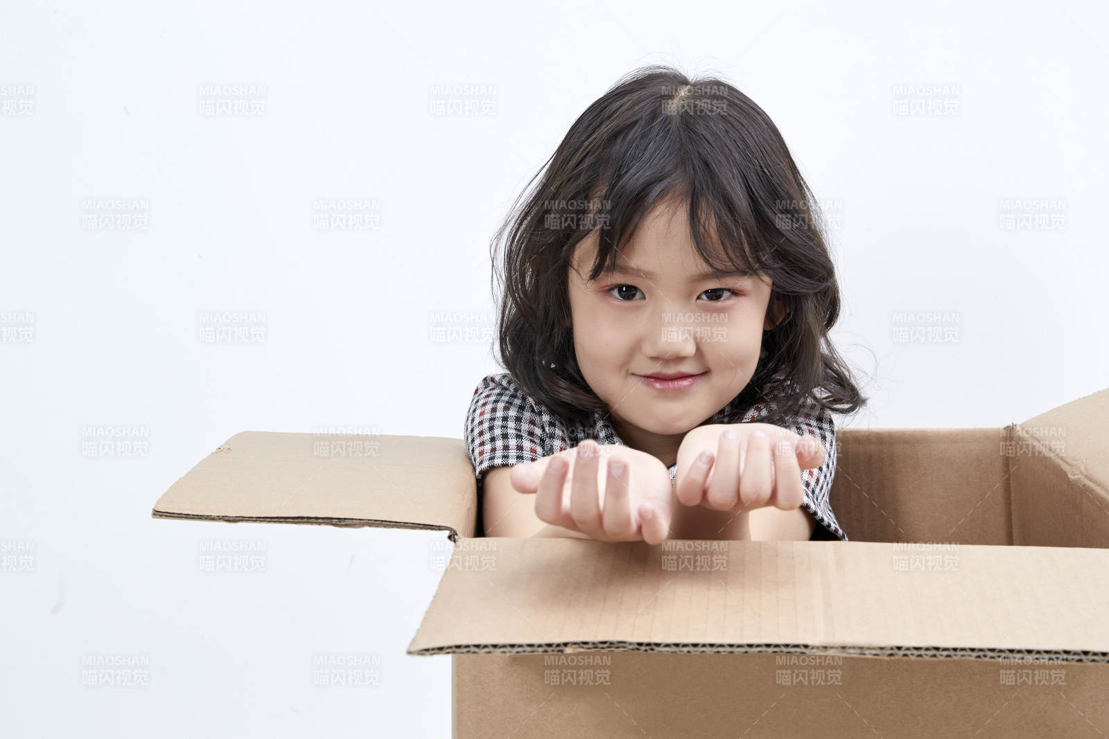 躲在纸箱中玩耍的调皮可爱亚洲小女孩儿童图片