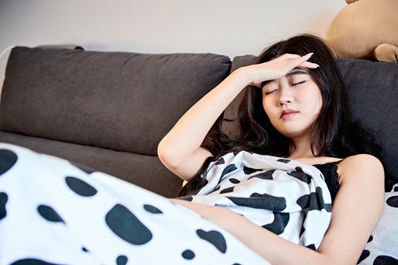 因为生病躺在床上的亚洲年轻少女图片
