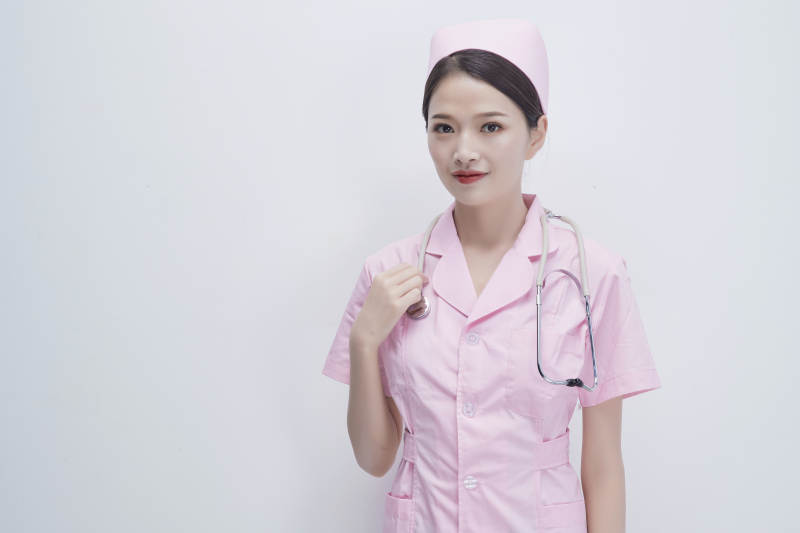 身穿粉色护士服佩戴听诊器的女性医护人员图片