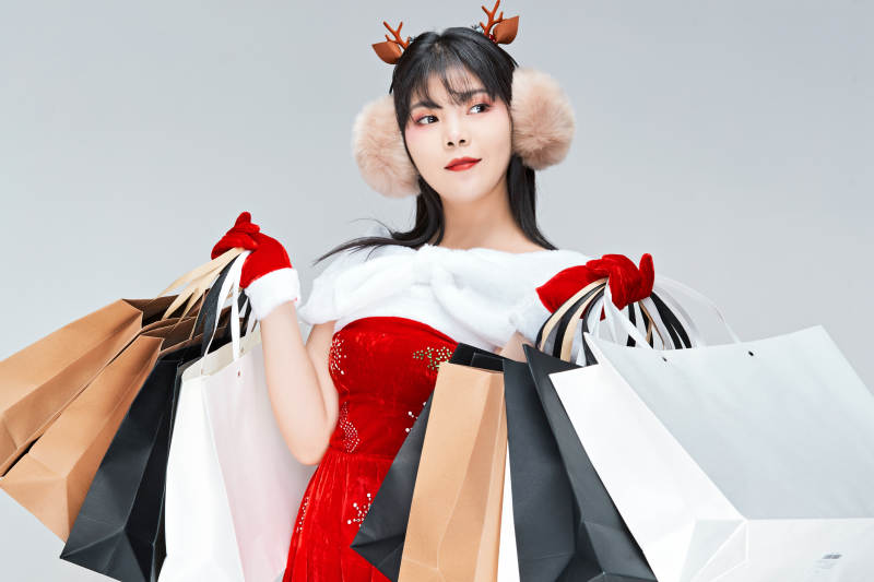 身穿圣诞服饰手提购物袋性感可爱的圣诞女郎图片