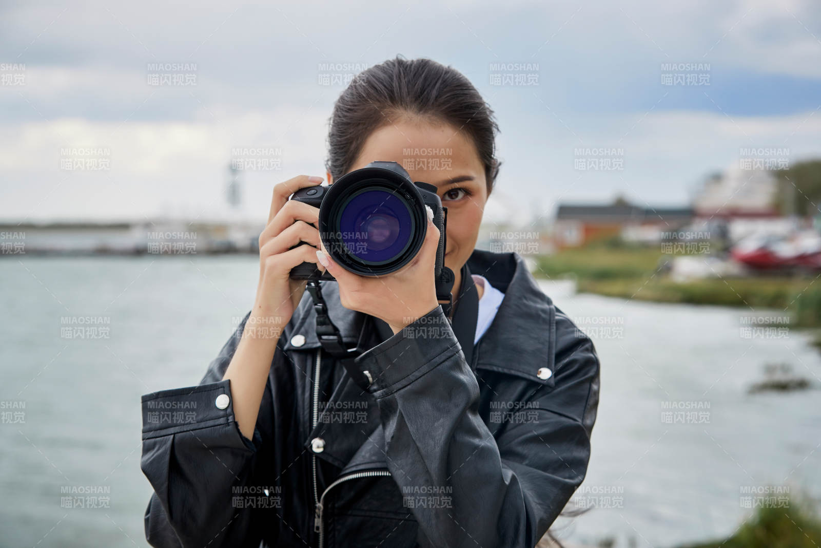 户外湖畔进行拍摄的亚洲青年女性摄影师图片
