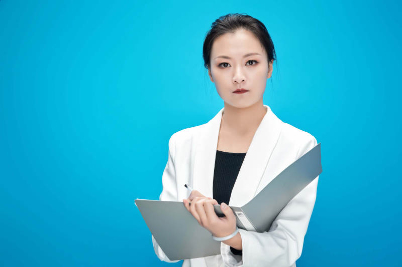 身穿西服拿着手机与文件夹的亚洲商务女士图片