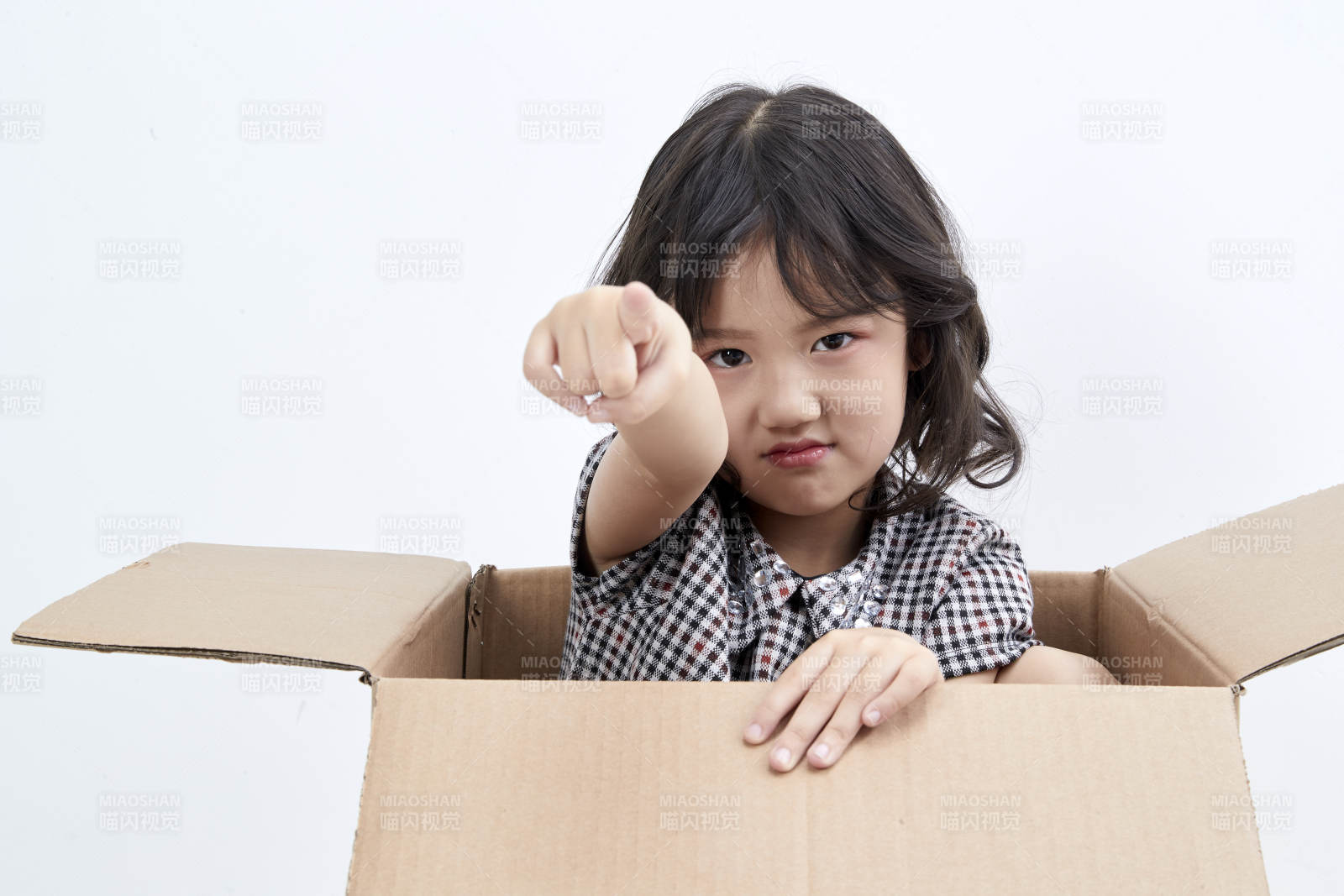 躲在纸箱中玩耍的调皮可爱亚洲小女孩儿童图片