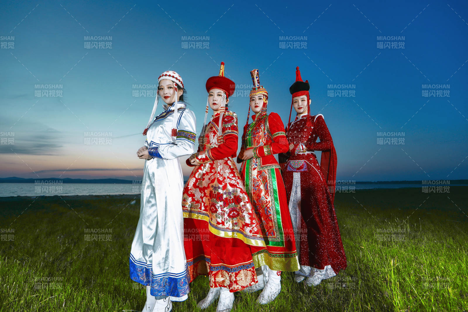 晚霞的草原湖畔穿蒙古族传统服饰的年轻女性图片