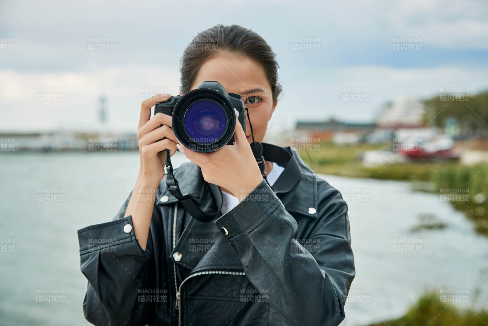 户外湖畔进行拍摄的亚洲青年女性摄影师图片
