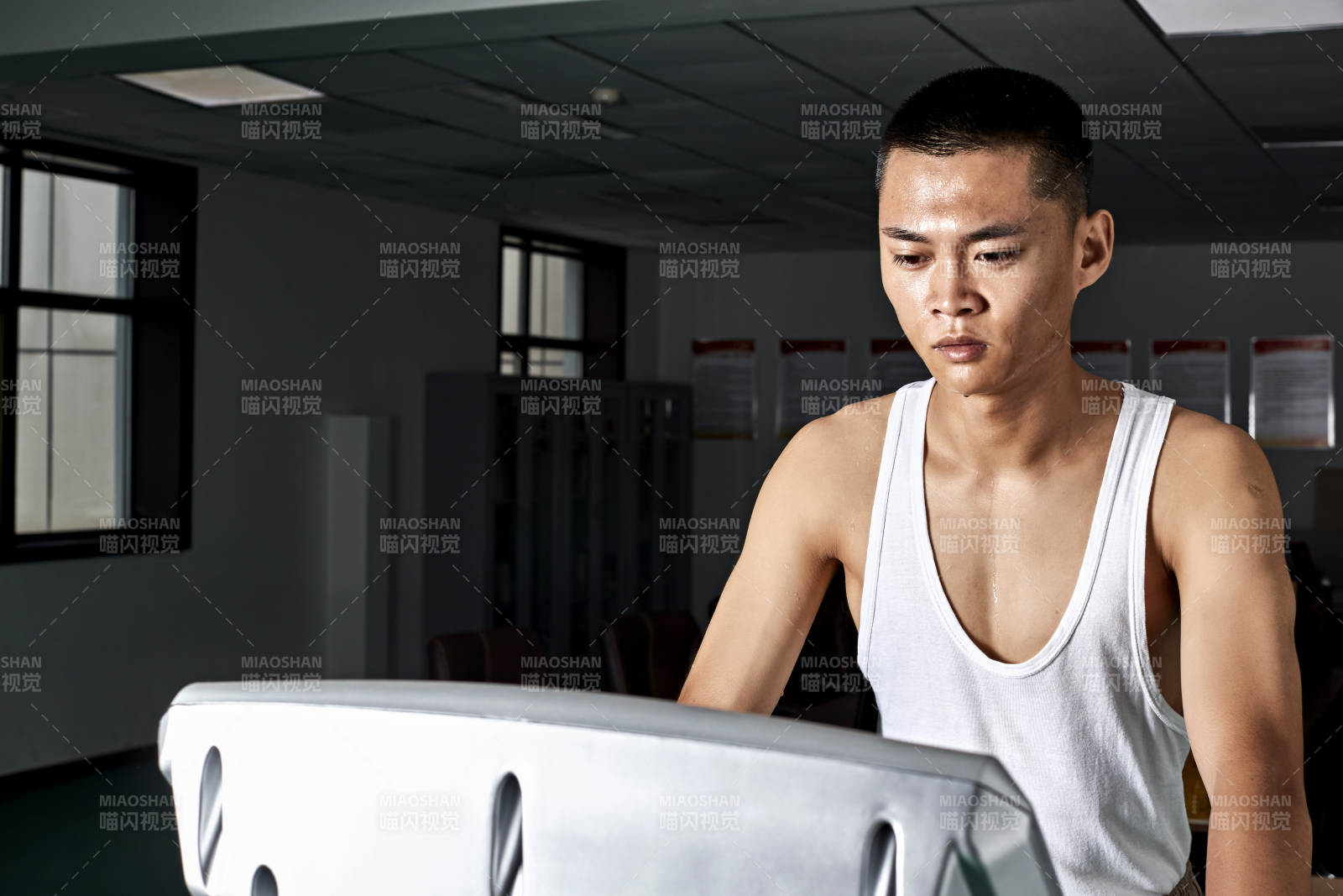 在室内用跑步机进行锻炼的亚洲健身男士形象图片