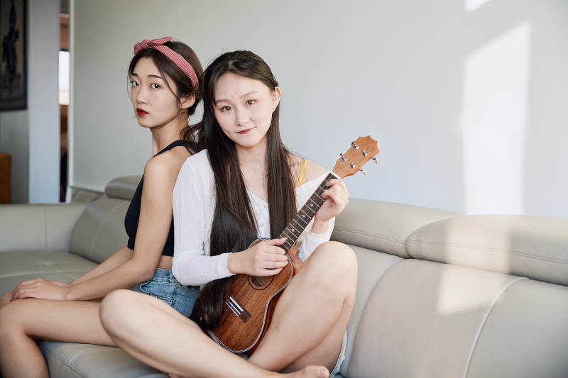 坐在沙发弹琴唱歌俩位美女闺蜜图片