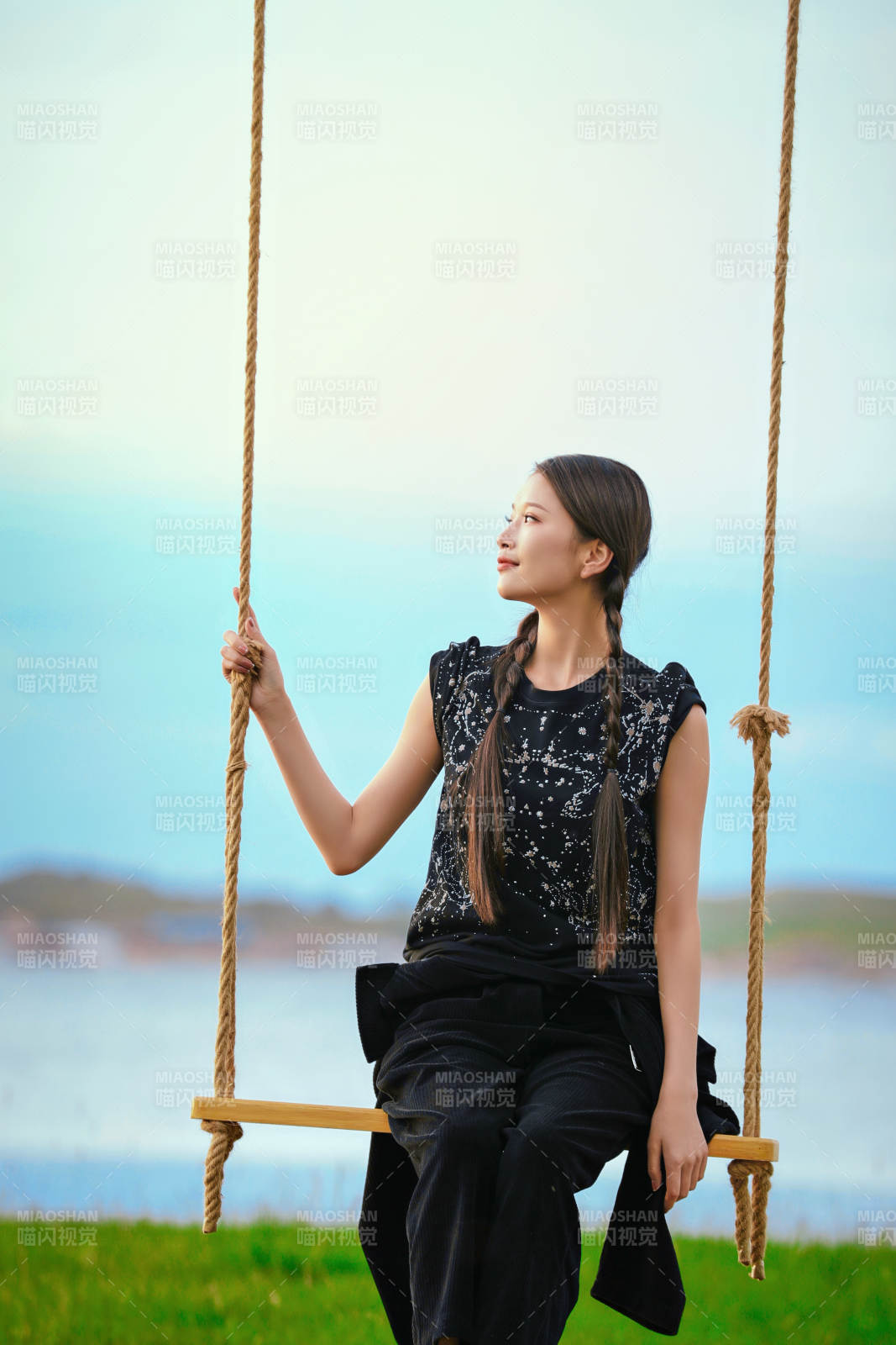 草原湖畔夕阳下荡秋千的亚洲少女图片