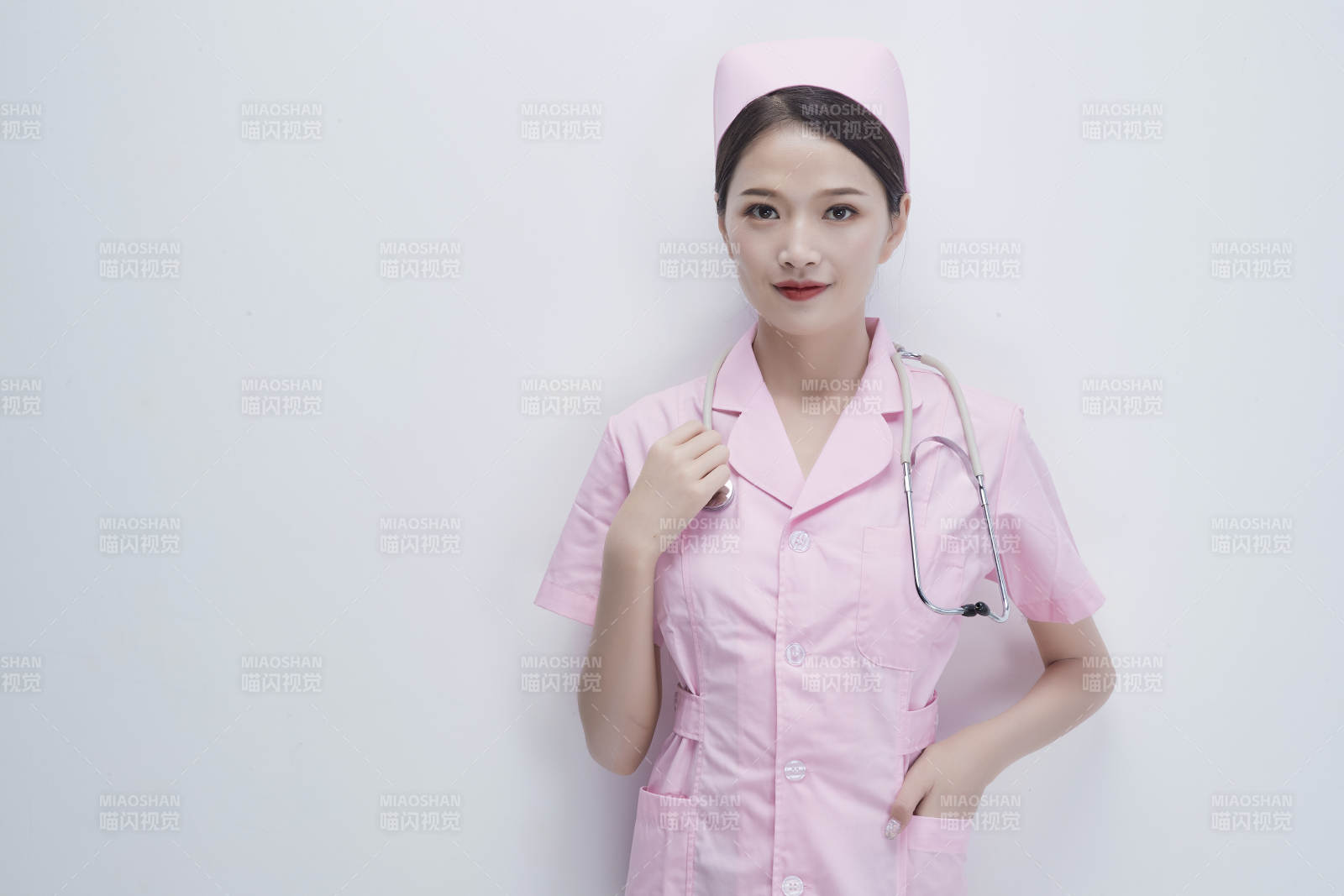 身穿粉色护士服佩戴听诊器的女性医护人员图片