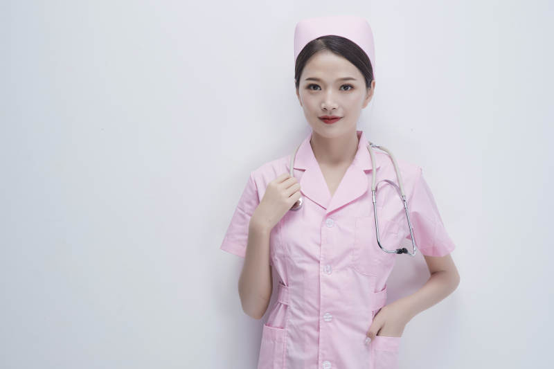 身穿粉色护士服佩戴听诊器的女性医护人员图片