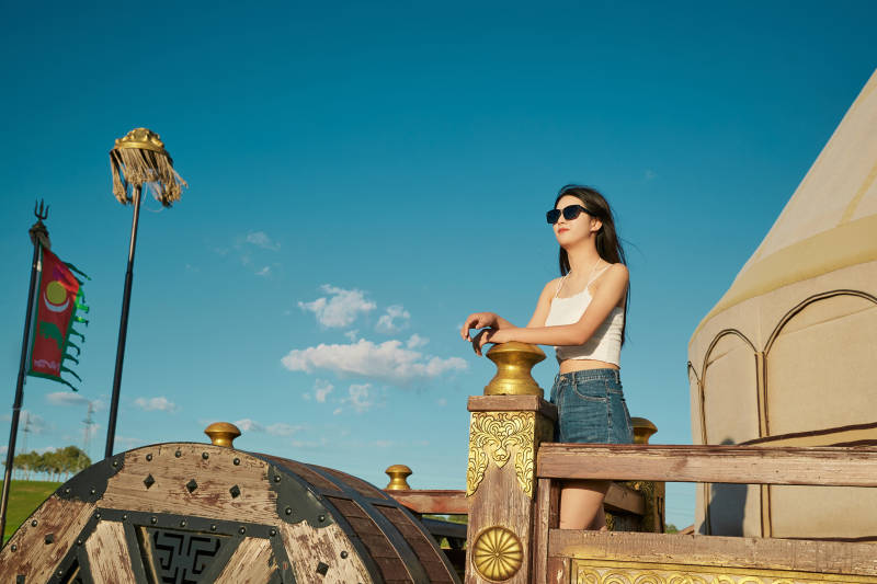 草原湿地公园游玩拍照的亚洲少女图片