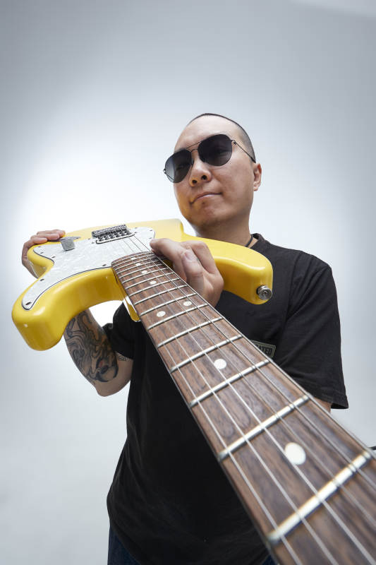 手持电吉他展示演奏的亚洲男性摇滚乐手人像图片