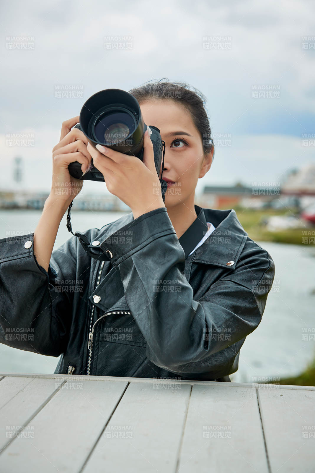 户外湖畔进行拍摄的亚洲青年女性摄影师图片
