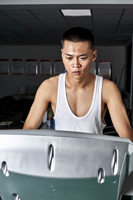 在室内用跑步机进行锻炼的亚洲健身男士形象图片