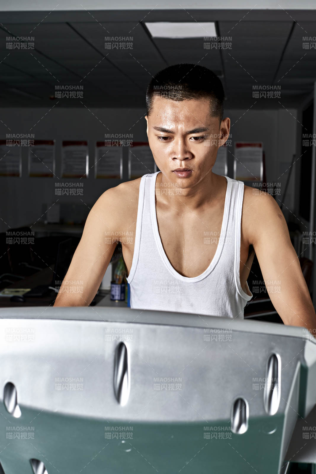 在室内用跑步机进行锻炼的亚洲健身男士形象图片