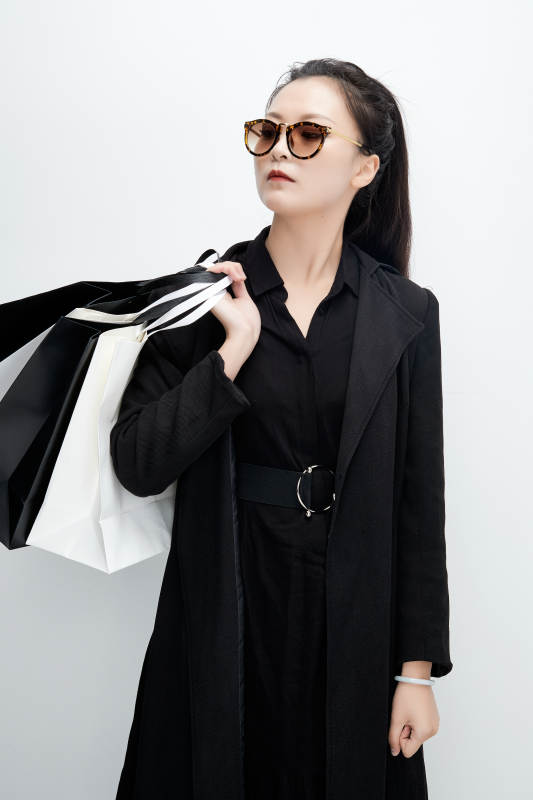 白色背景下手提购物袋时尚美丽的亚洲少女图片