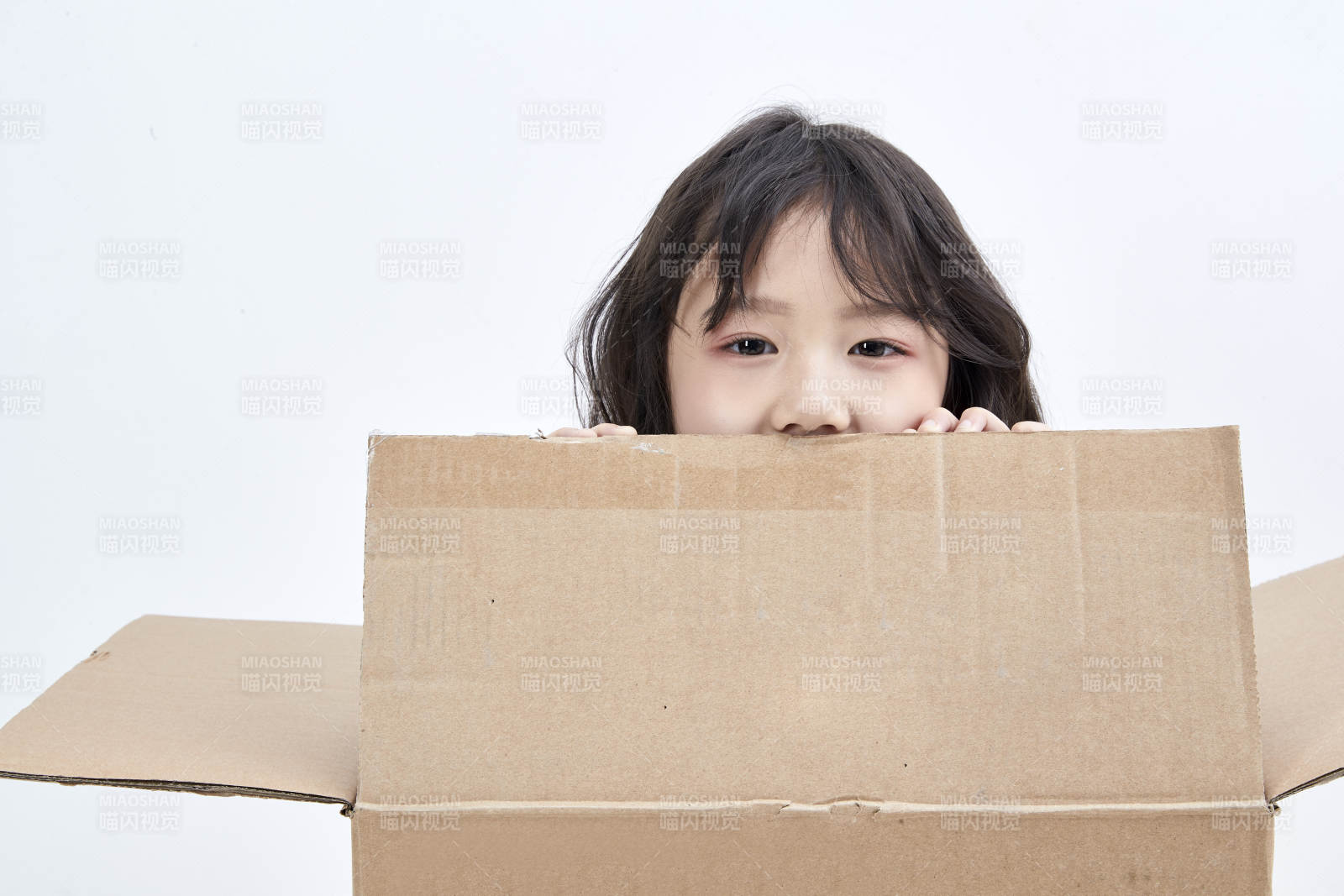 躲在纸箱中玩耍的调皮可爱亚洲小女孩儿童图片