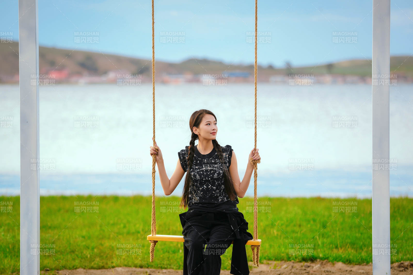 草原湖畔夕阳下荡秋千的亚洲少女图片