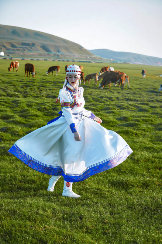 草原上穿着蒙古族传统服饰的亚洲年轻美少女图片