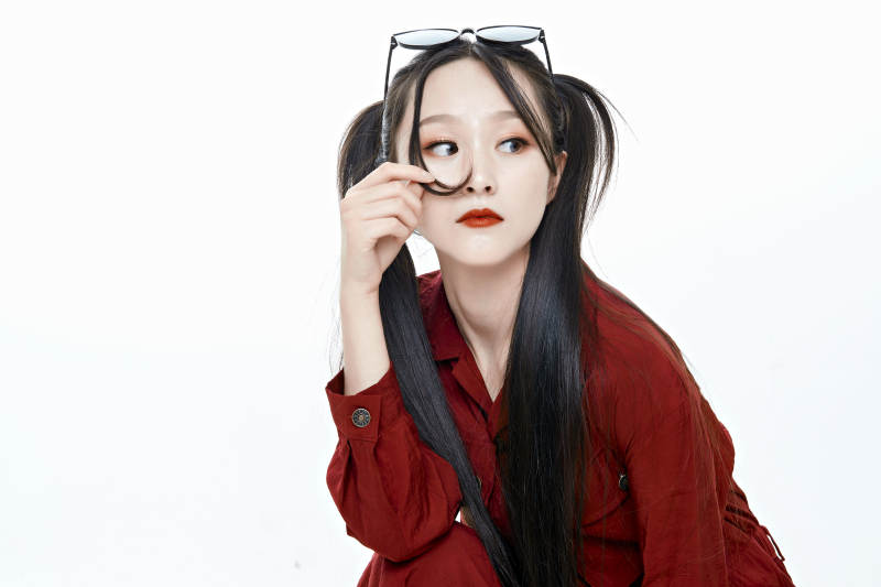 白色背景的亚洲戴墨镜年轻少女的肖像人像图片