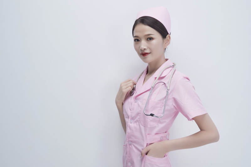 身穿粉色护士服佩戴听诊器的女性医护人员图片