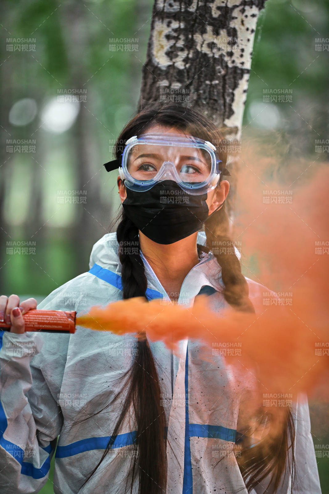手执彩烟身穿防护服装的女性医疗人员图片