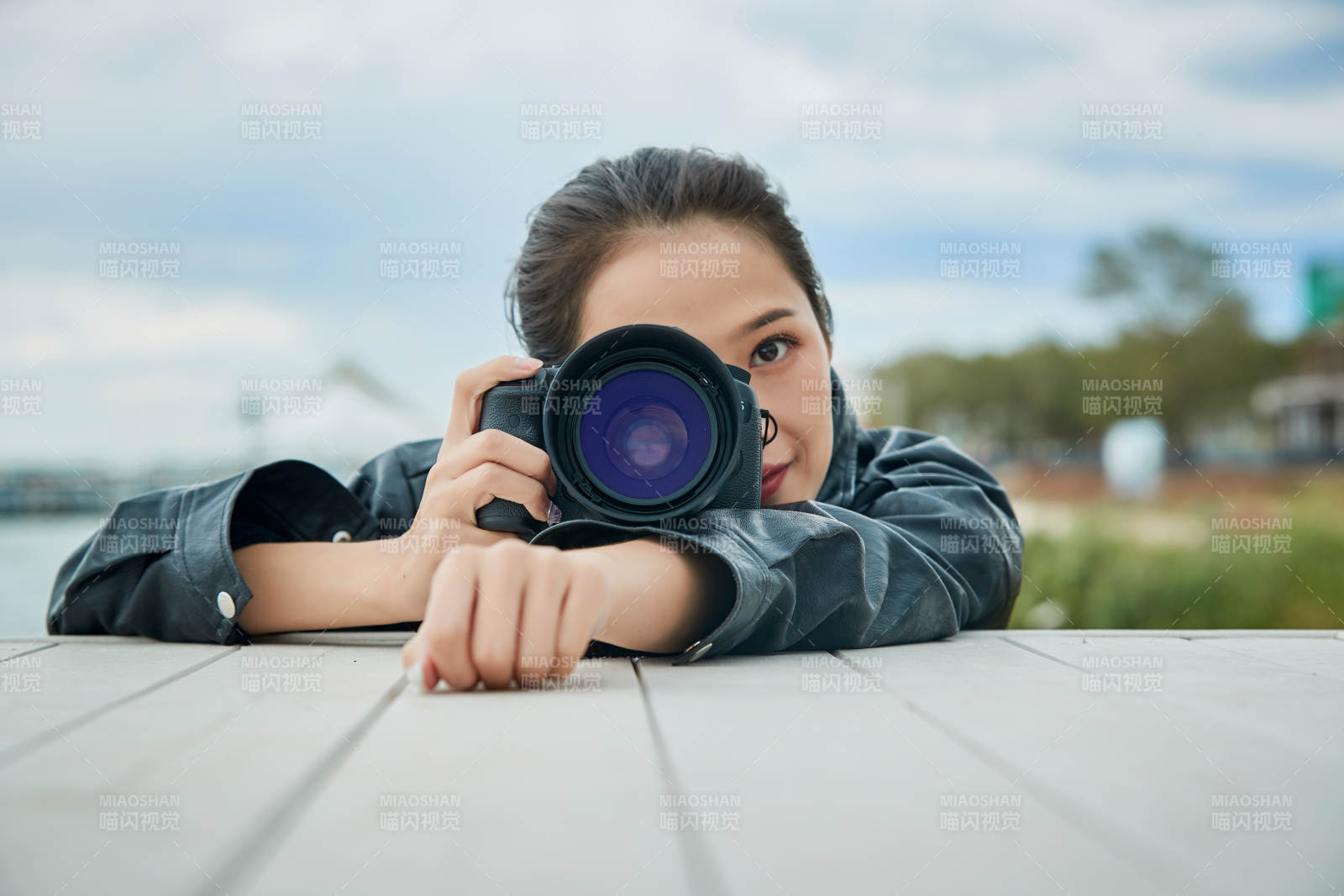 户外湖畔进行拍摄的亚洲青年女性摄影师图片