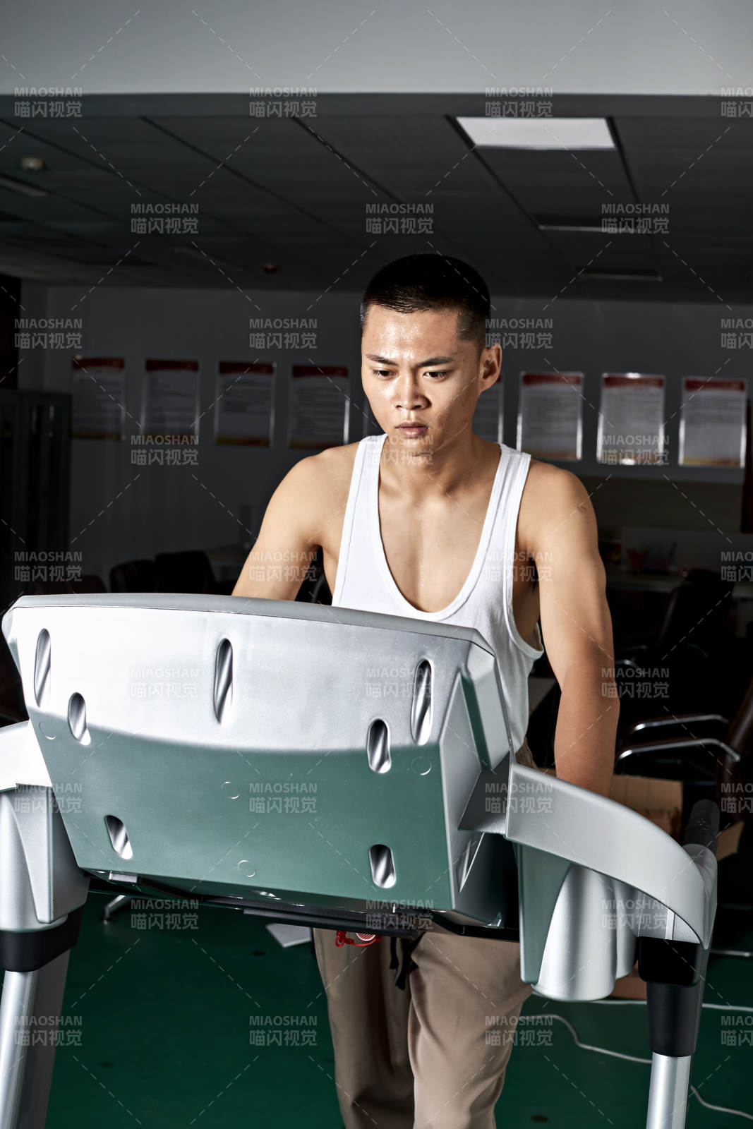 在室内用跑步机进行锻炼的亚洲健身男士形象图片