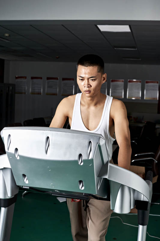 在室内用跑步机进行锻炼的亚洲健身男士形象图片