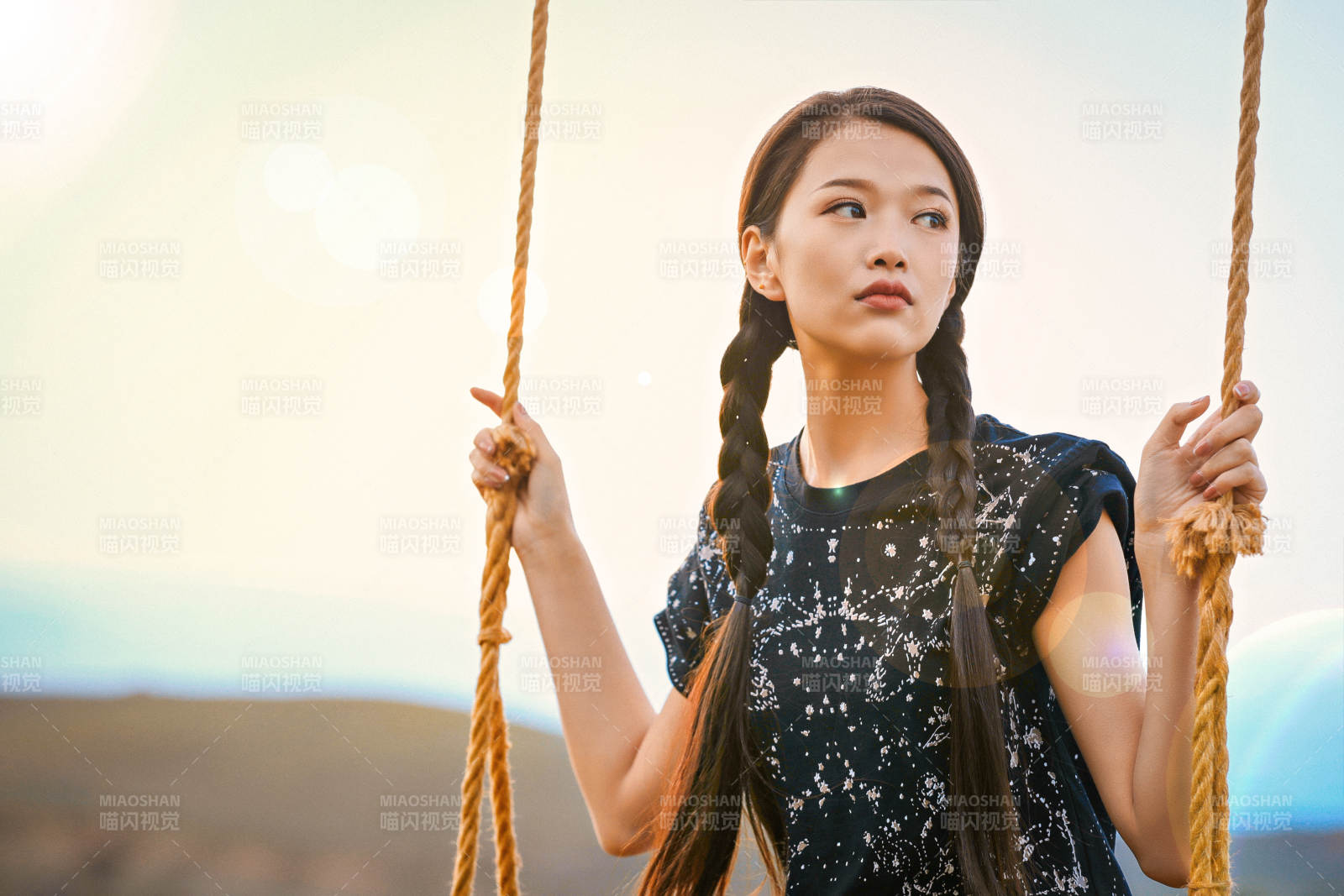 草原湖畔夕阳下荡秋千的亚洲少女图片