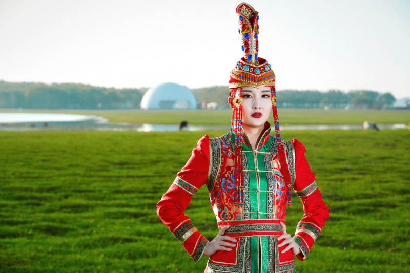 草原上穿着蒙古族传统服饰的亚洲年轻美少女图片