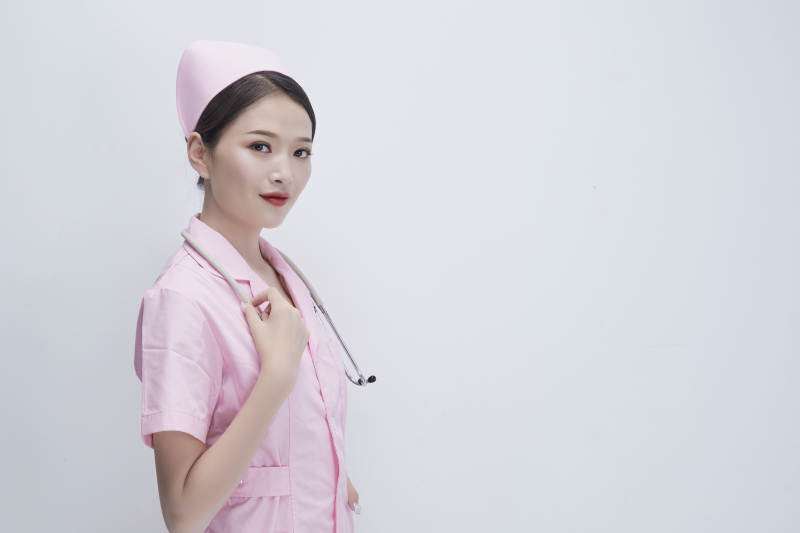 身穿粉色护士服佩戴听诊器的女性医护人员图片