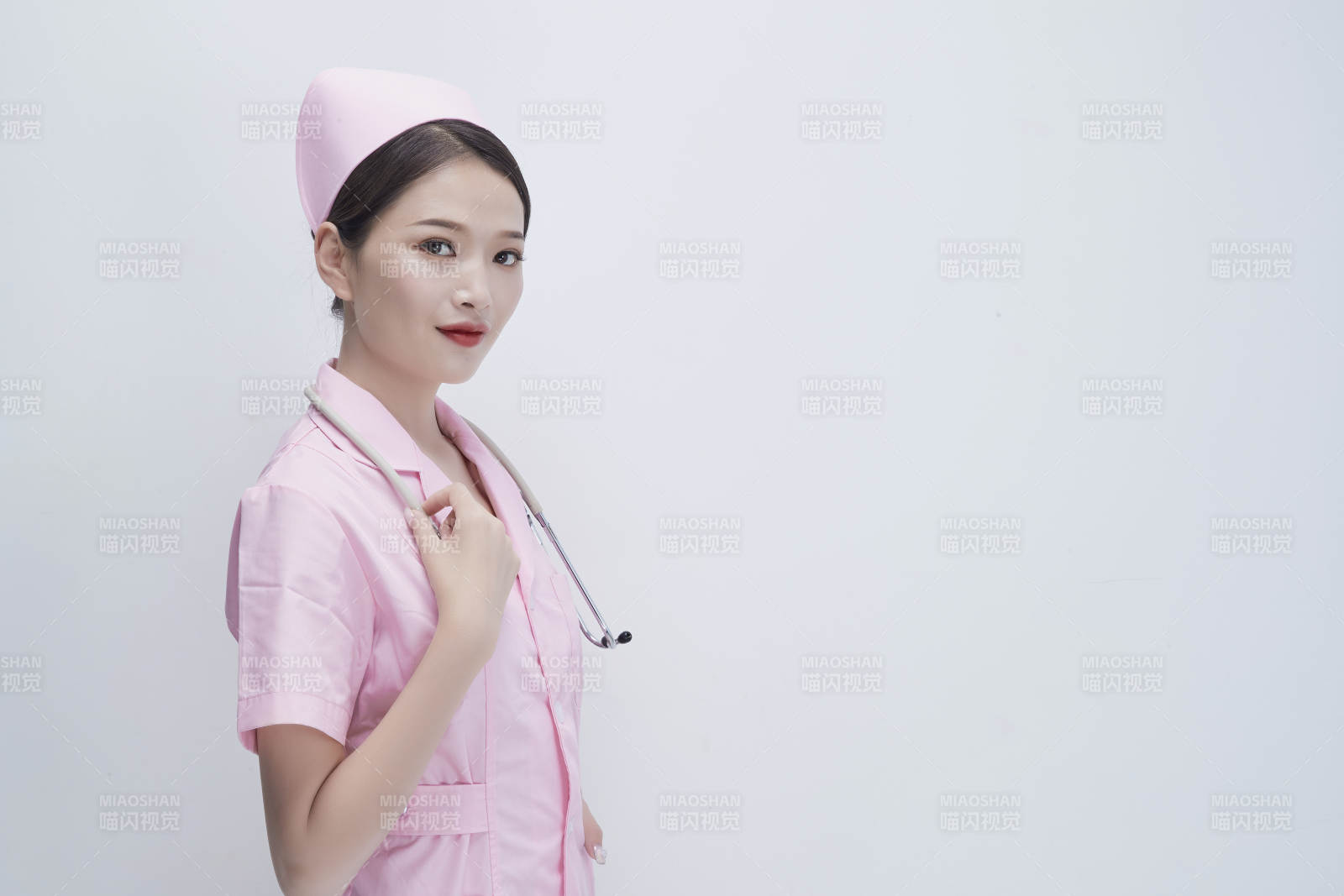 身穿粉色护士服佩戴听诊器的女性医护人员图片