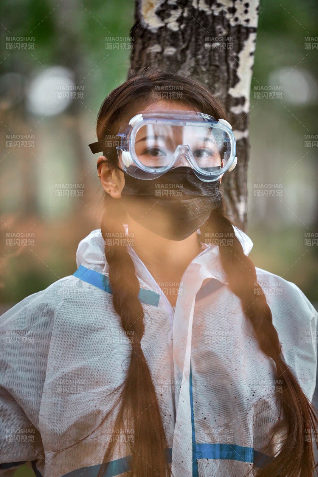 手执彩烟身穿防护服装的女性医疗人员图片