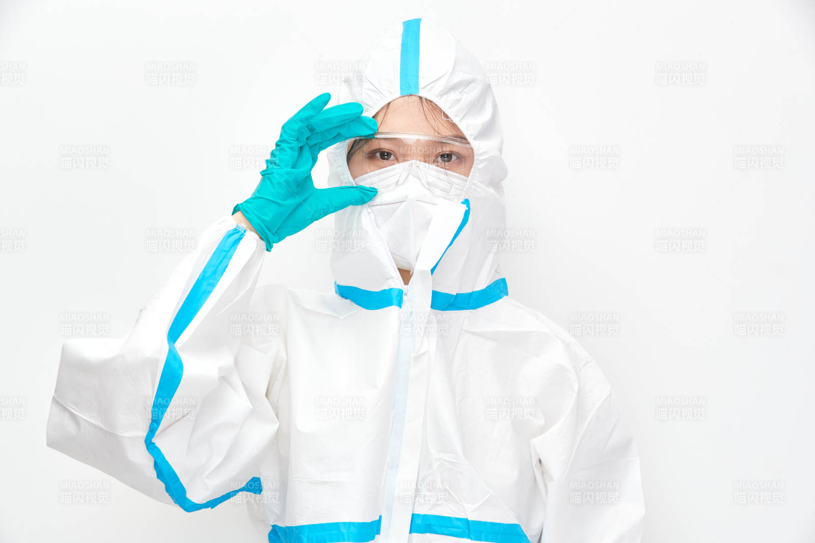 穿白色防护服佩戴护目镜口罩的女性医疗人员图片
