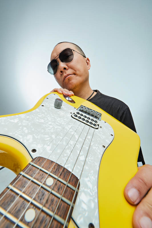 手持电吉他展示演奏的亚洲男性摇滚乐手人像图片