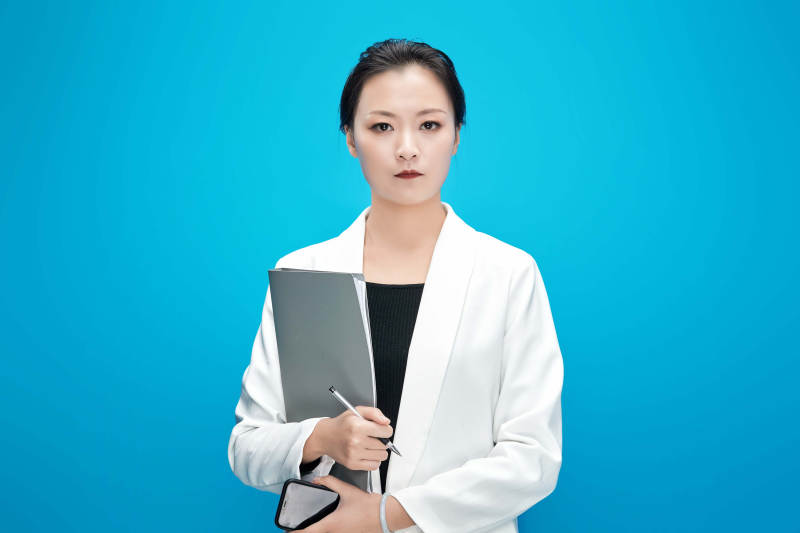 身穿西服拿着手机与文件夹的亚洲商务女士图片