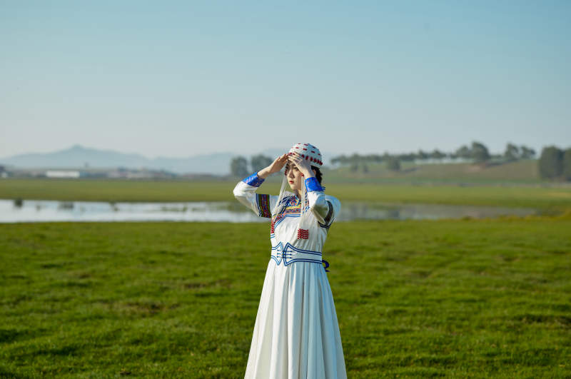 草原上穿着蒙古族传统服饰的亚洲年轻美少女图片